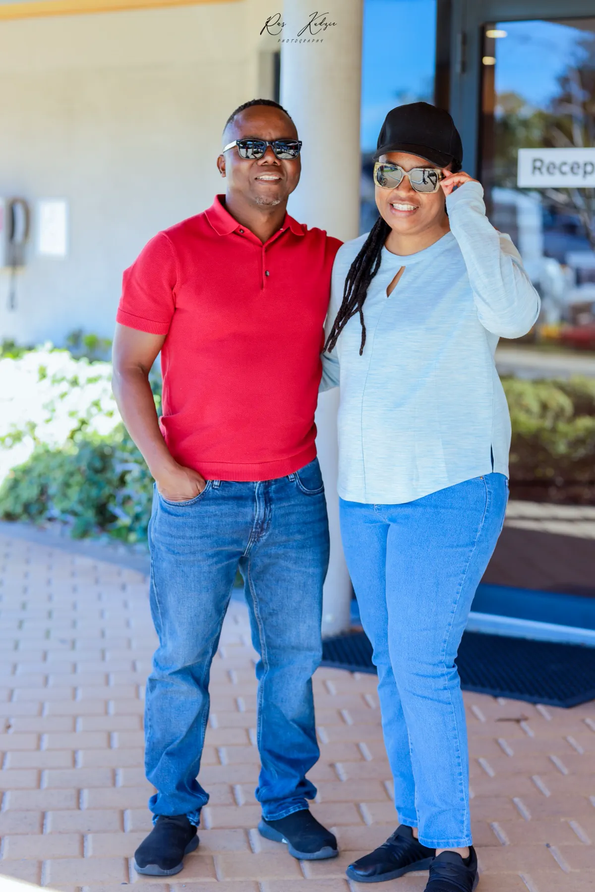 A couple posing together outside a reception entrance