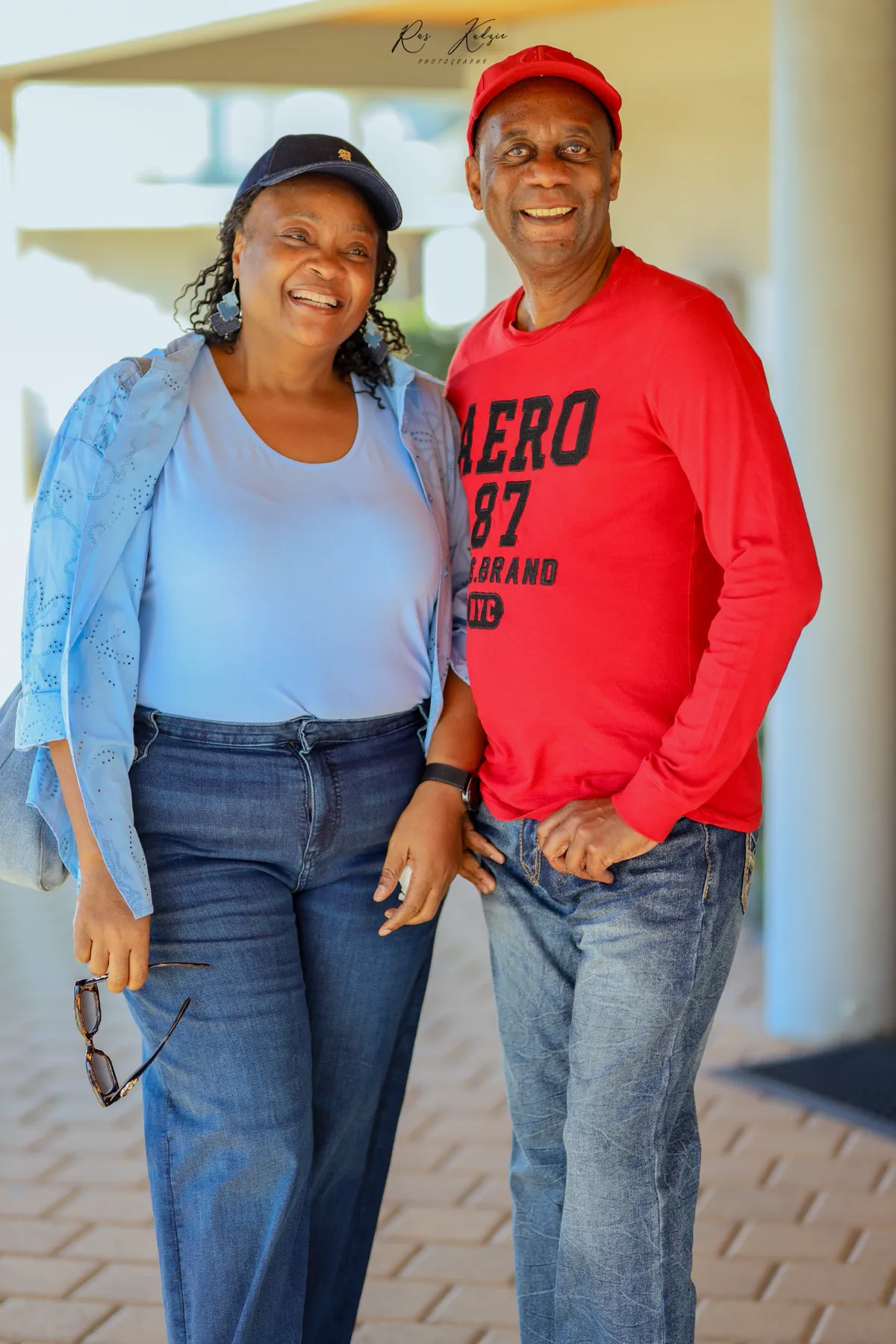 A joyful couple laughing together in coordinated red and blue
