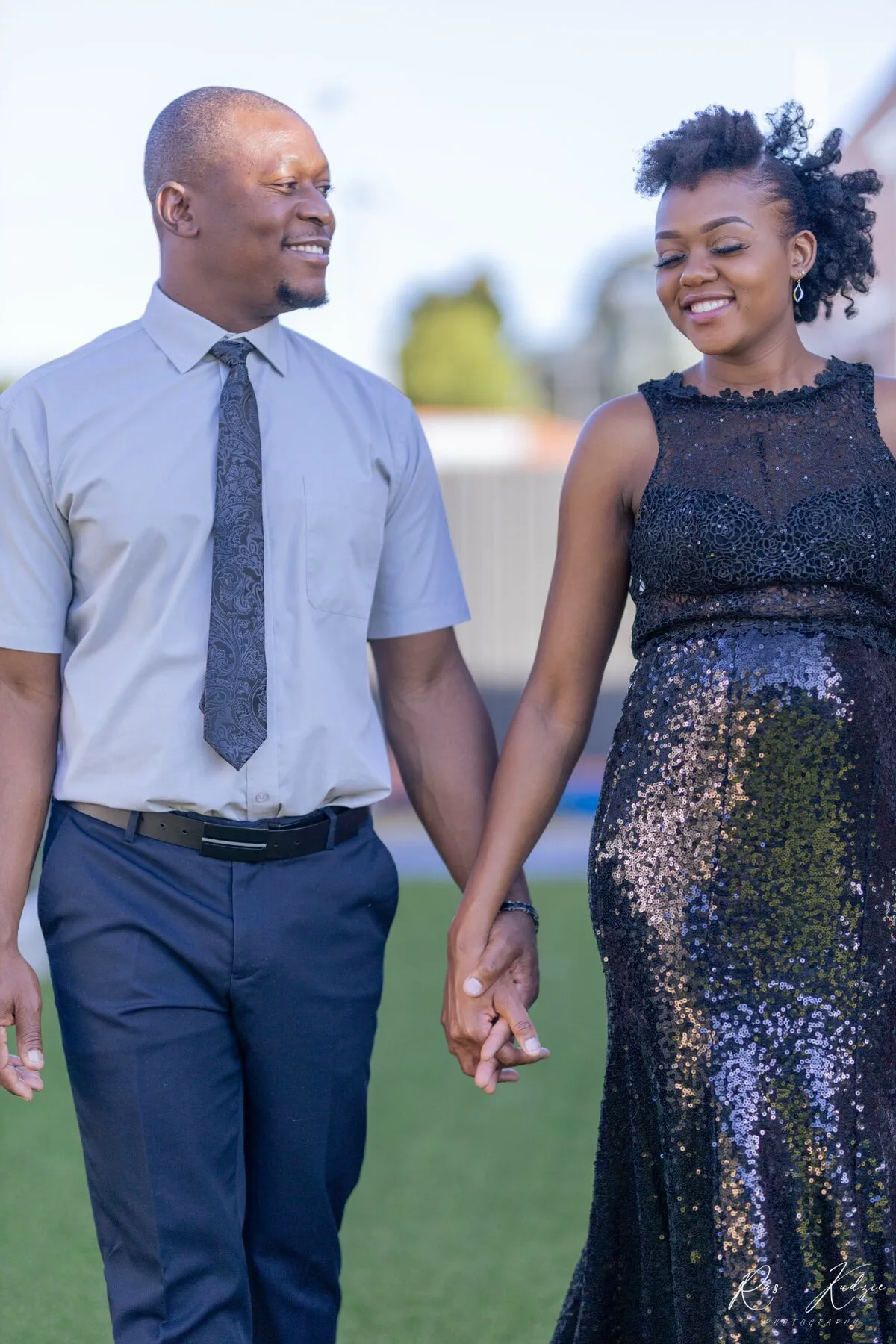 An expectant couple holding hands during a maternity portrait