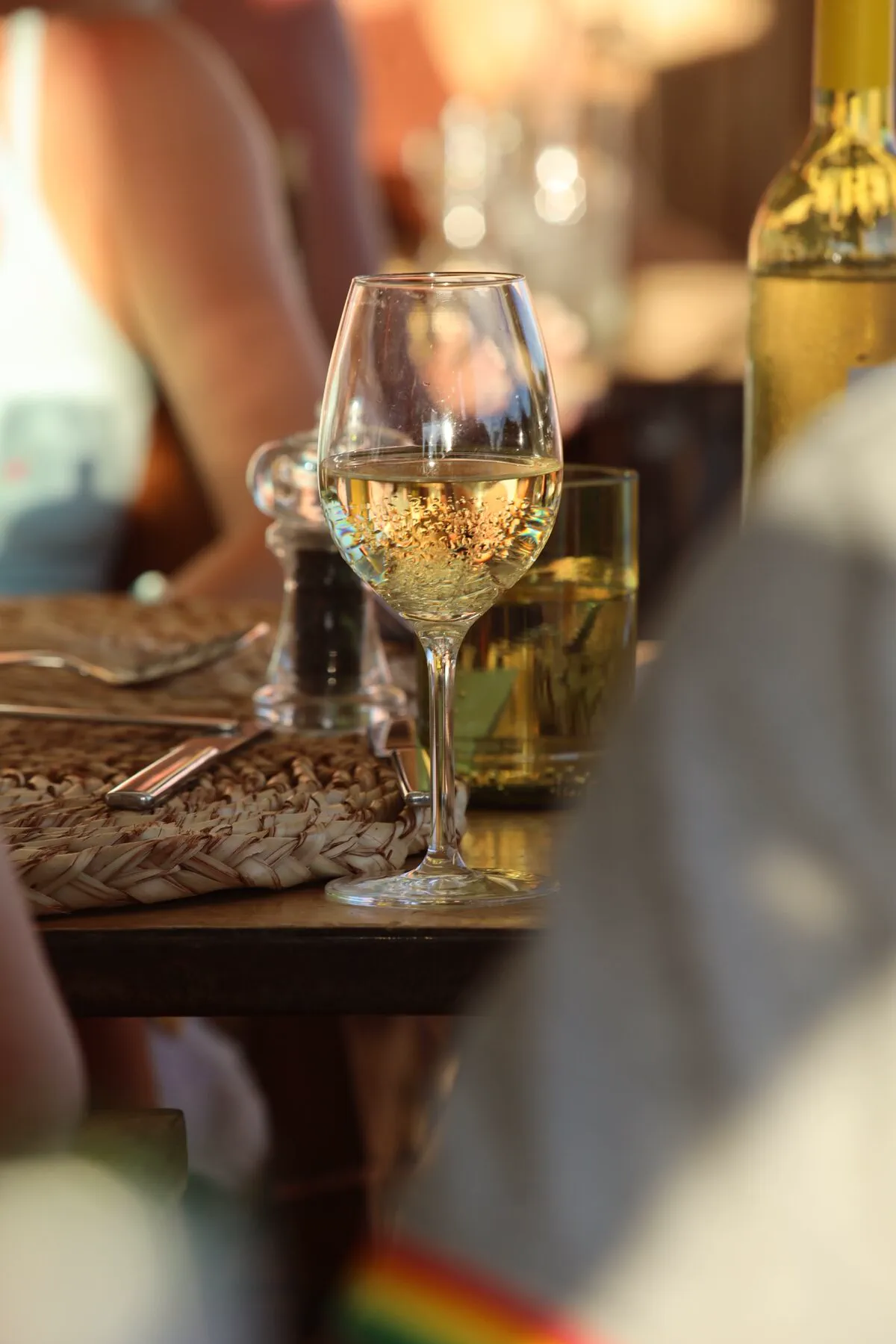 A glass of sparkling wine glowing in warm restaurant light