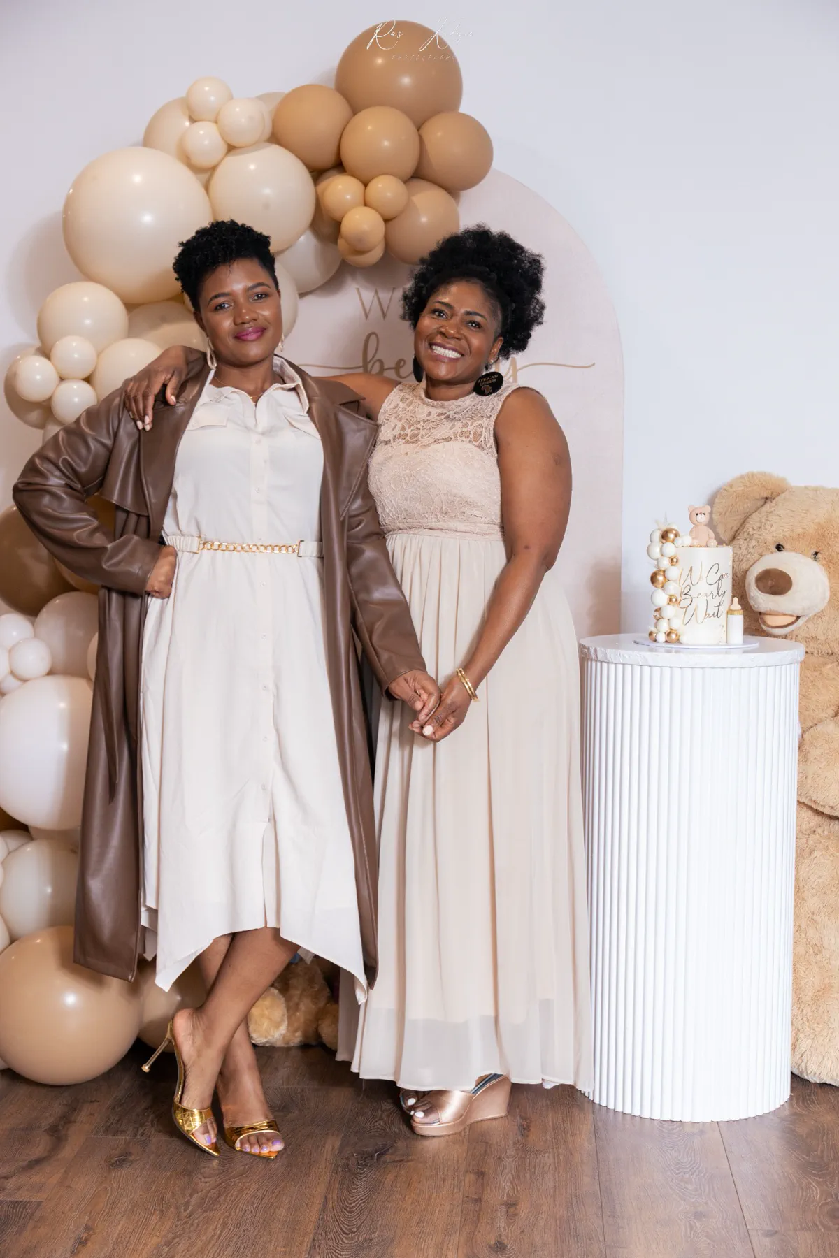 Two women smiling together beside the baby shower display