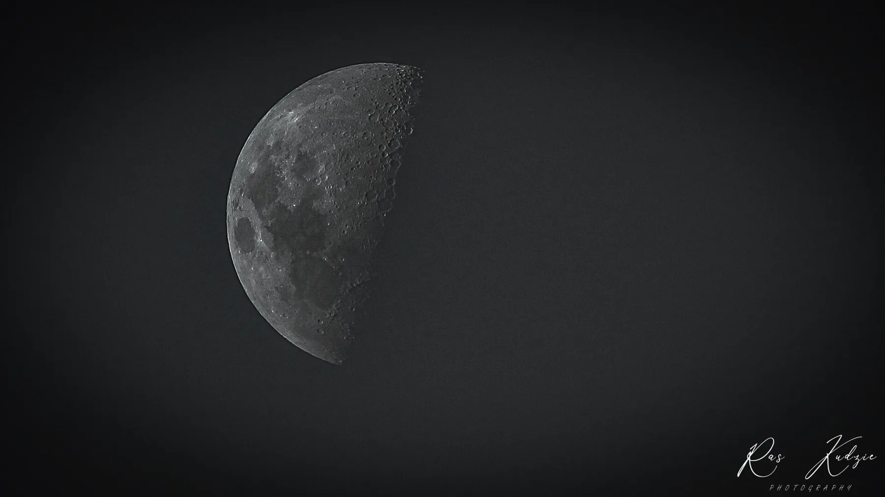 A detailed crescent moon emerging from a dark night sky
