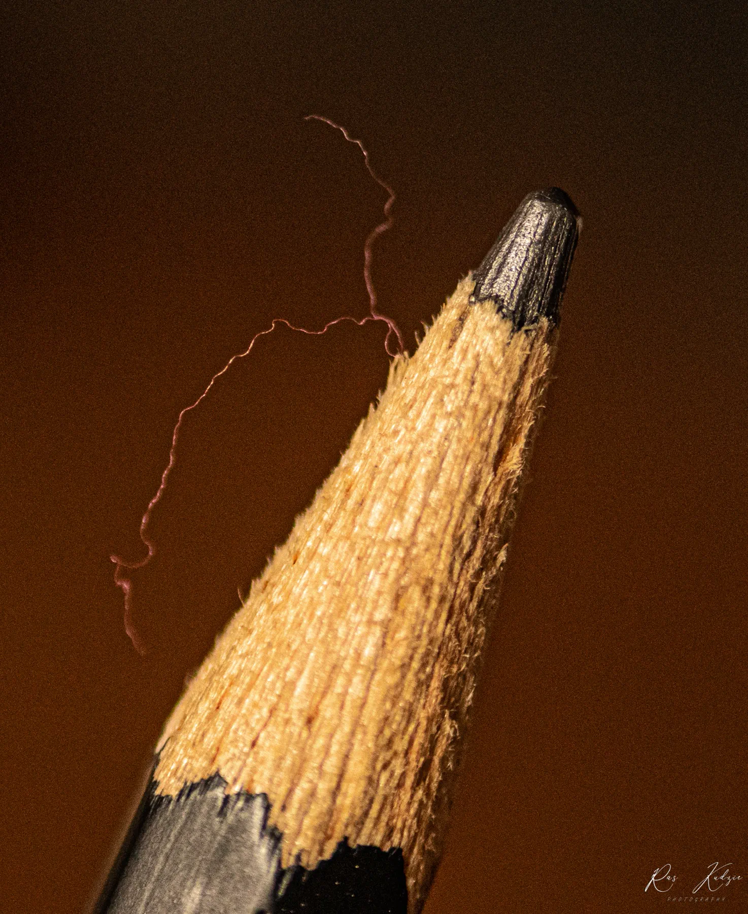 An extreme close study of a sharpened pencil and a loose fibre
