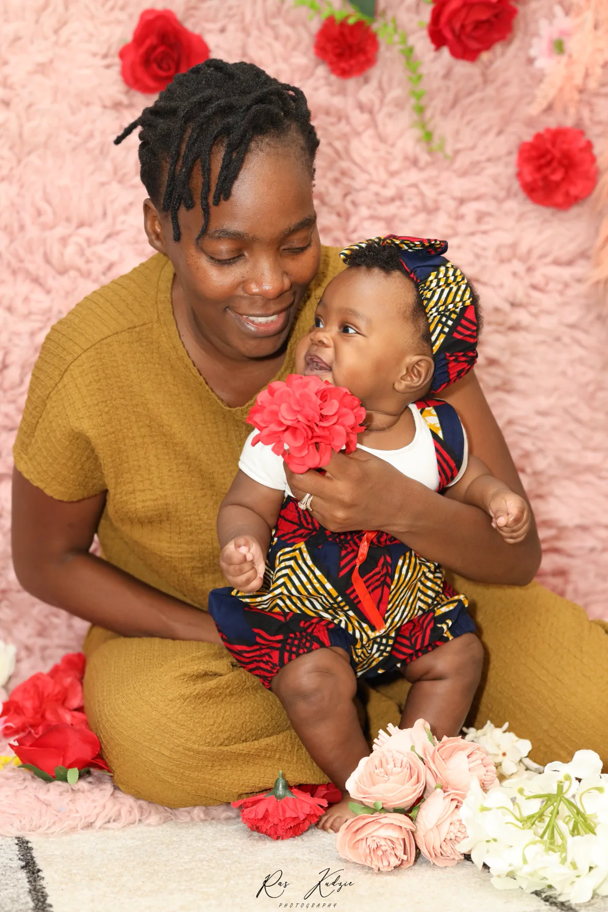 A mother smiling at her baby during a warm family portrait session