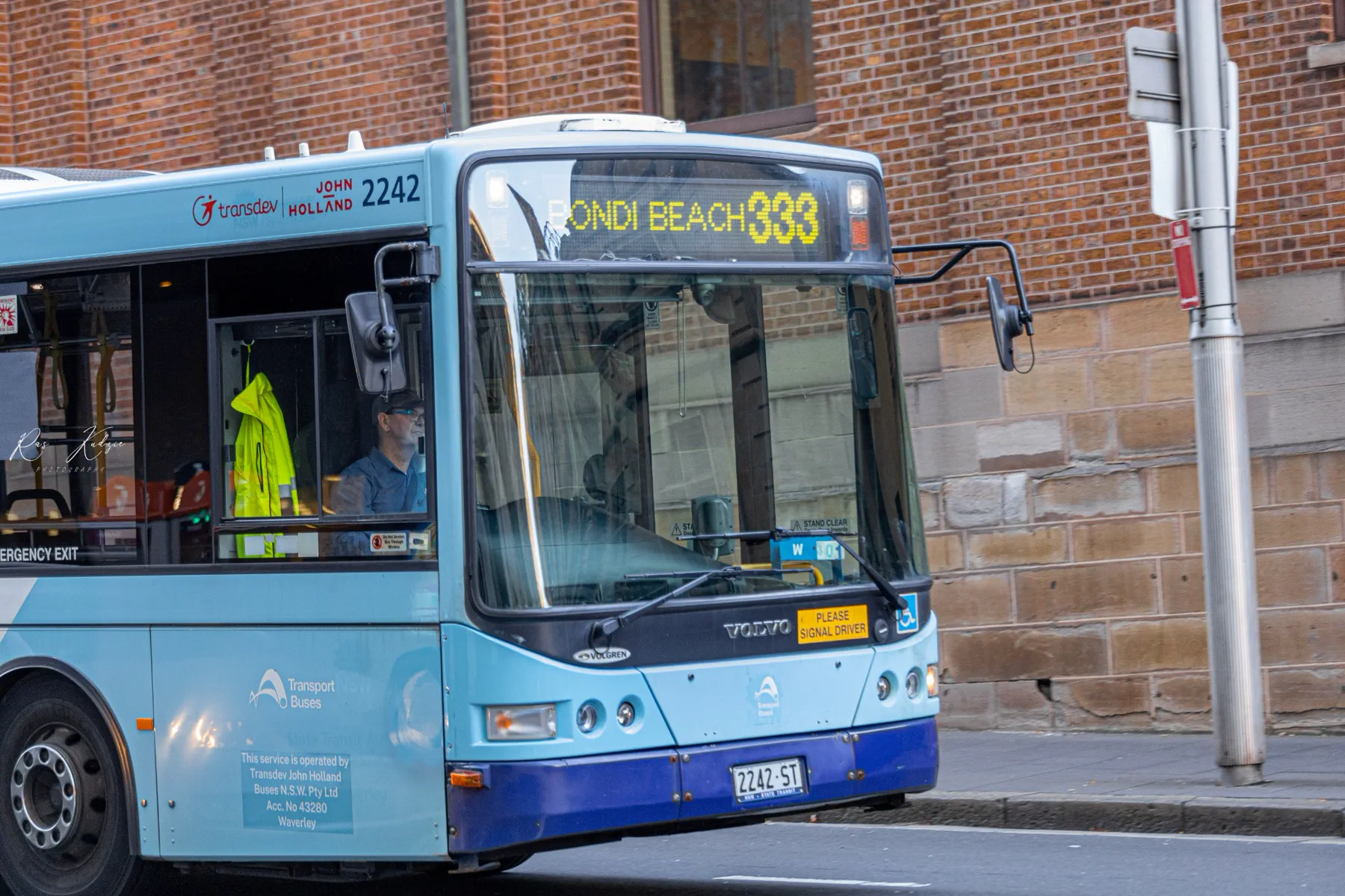 A Bondi Beach bus passing a brick-lined Sydney street