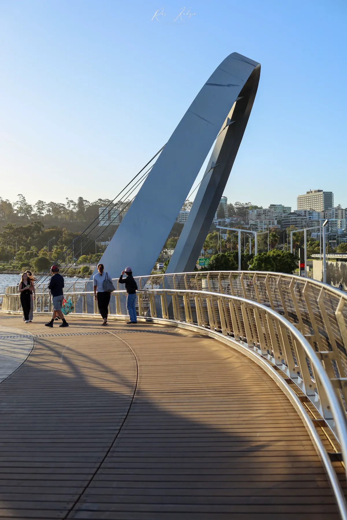 People walking across the curved Elizabeth Quay Bridge