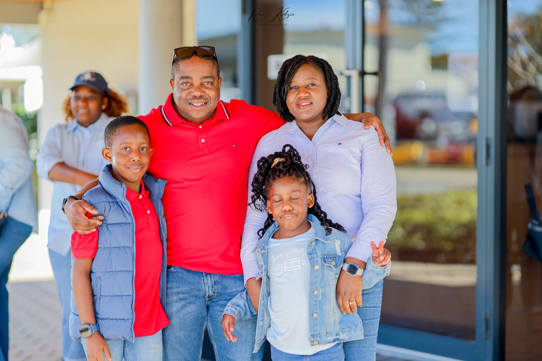 A family of four gathered together in coordinated red and blue