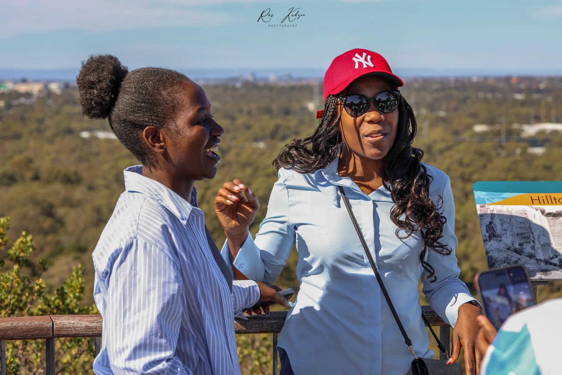 Two friends sharing a candid laugh at a scenic lookout