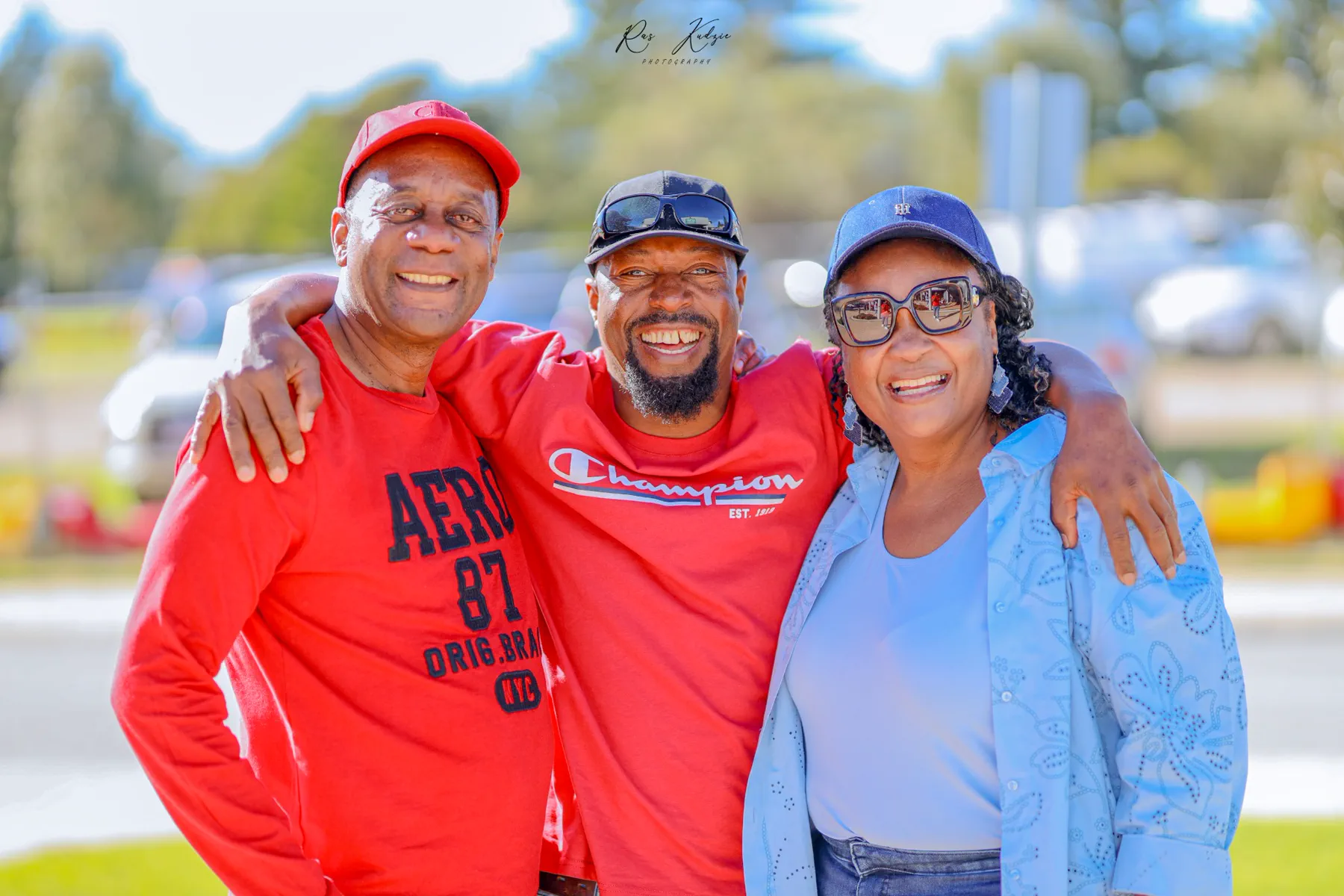 Three friends smiling together in coordinated red and blue