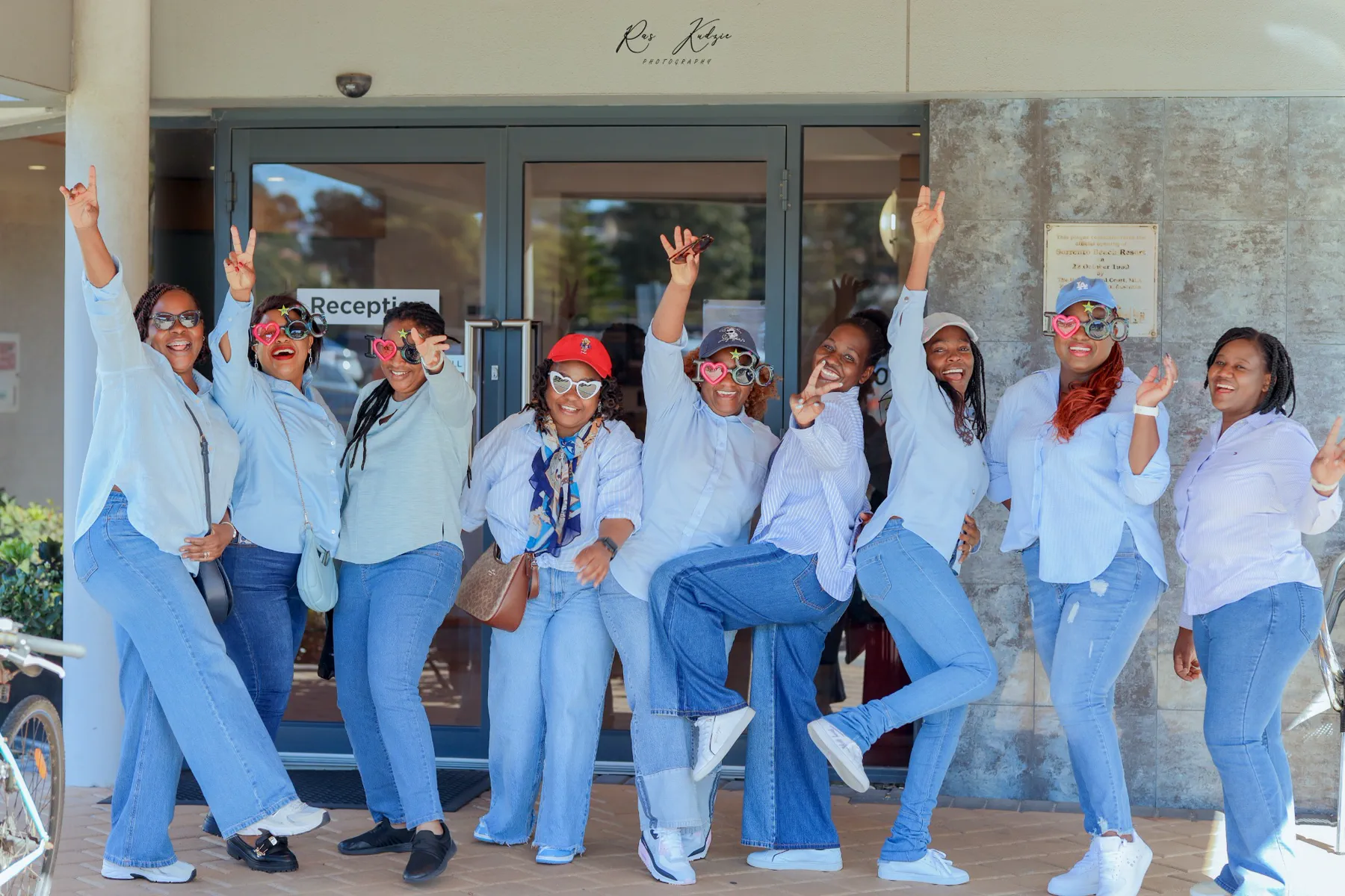 A joyful group of women posing together in coordinated blue outfits